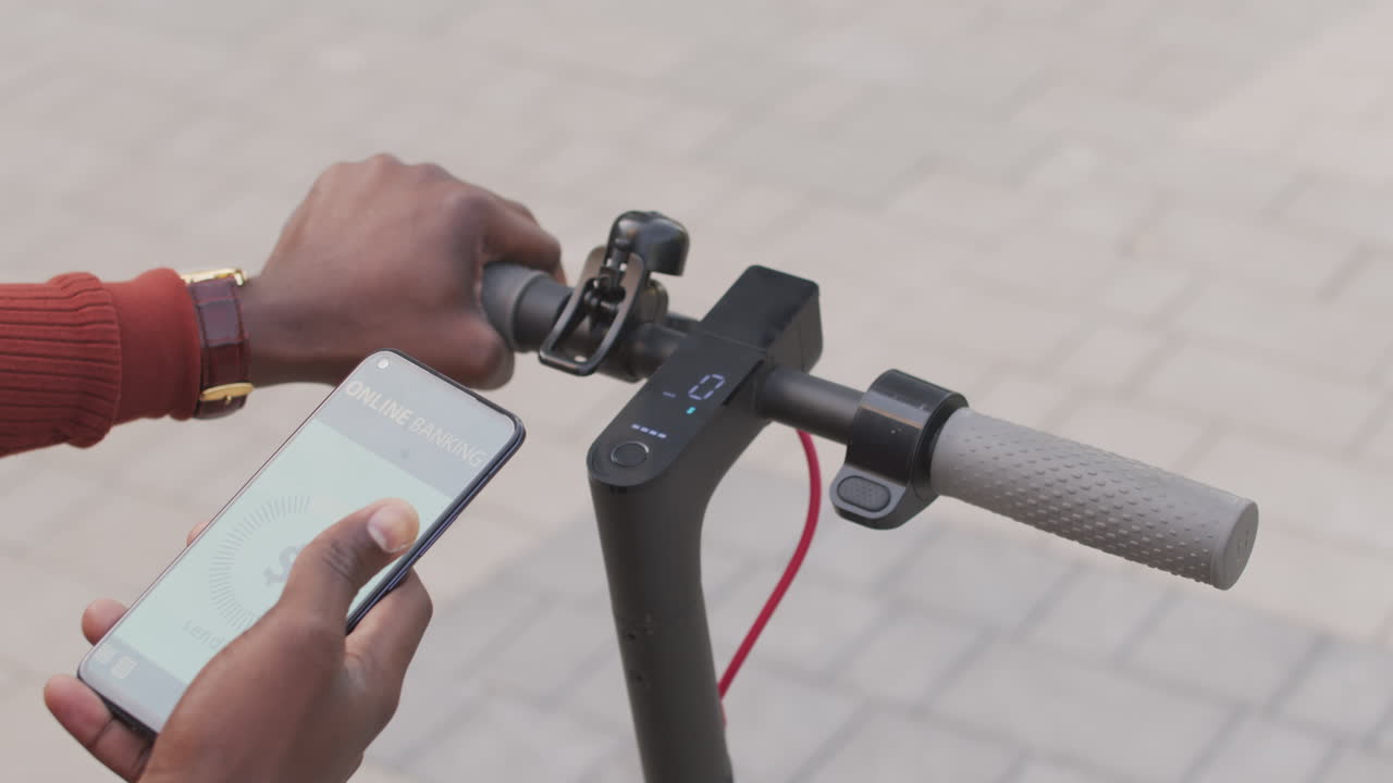 Man Activating E-Scooter with App on Smartphone