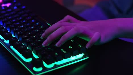 las manos de la chica gamer usando el teclado mientras juega videojuegos
