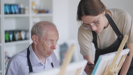 like senior friends attending together at a painting class. small group taking a variety of fun classes together. a group of elderly people attend a master class on drawing together spending time.