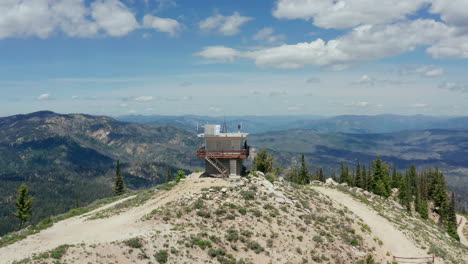 Aerial-circling-fire-watch-station-on-mountain-with-person-on-lookout