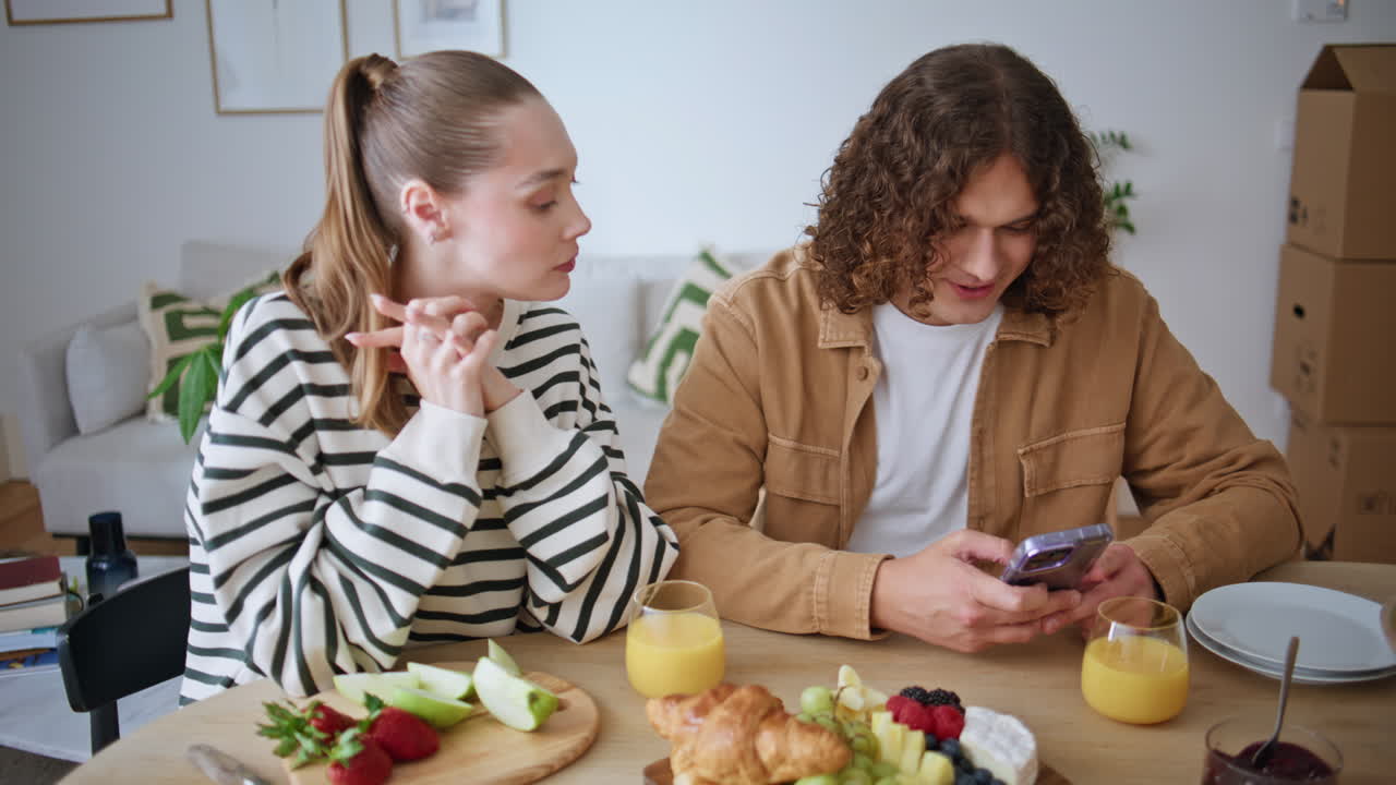 Married pair breakfasting together in modern apartment closeup. Woman eating