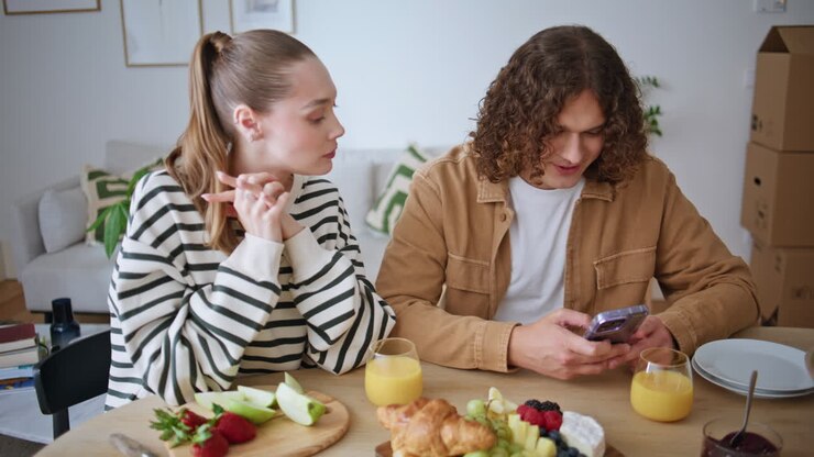 Married pair breakfasting together in modern apartment closeup. Woman eating