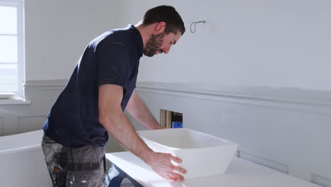 Fontanero-Instalando-Nuevo-Lavabo-En-El-Baño.