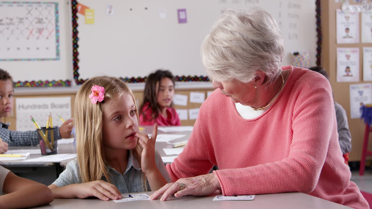 professora ajudando uma jovem estudante a aprender a contar o tempo na aula