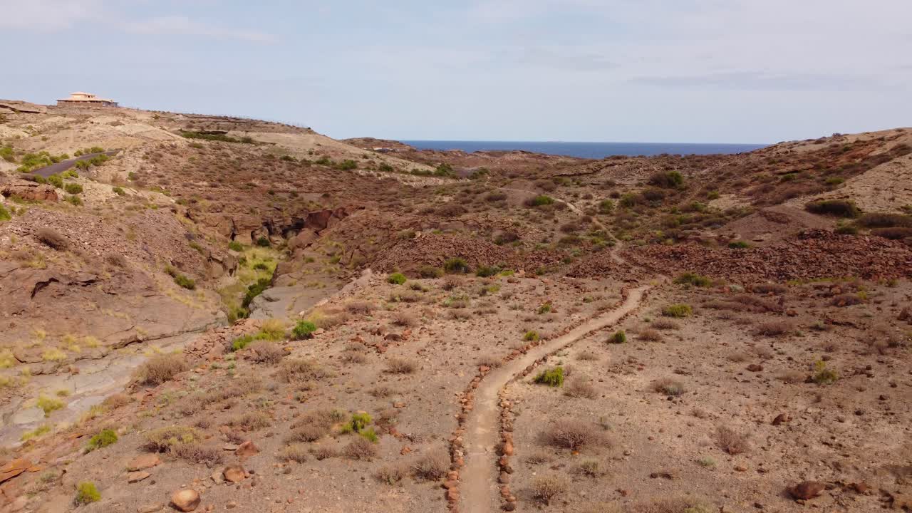 수직으로 상승하는 드론 영상: 테네리페 사막의 산과 바다 배경