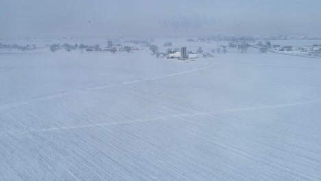 Vista-Aérea-Del-Amanecer-Temprano-En-La-Mañana-Después-De-Una-Caída-De-Nieve-En-El-Campo-Amish-Como-Senn-Por-S-Drone