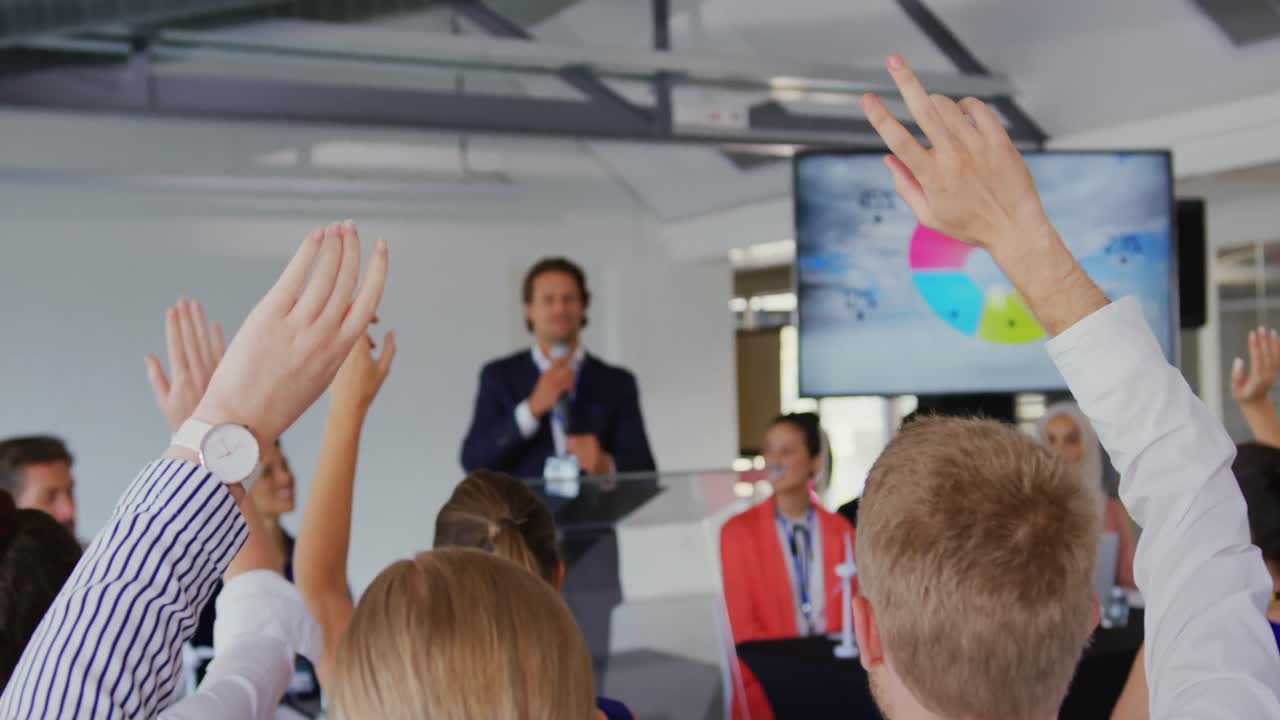 Uomo d'affari che invita il pubblico a porre domande a una conferenza aziendale