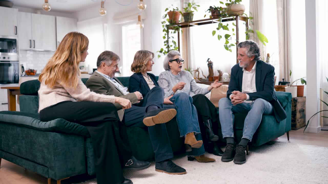 Gruppe af venner har en livlig samtale i en moderne stue