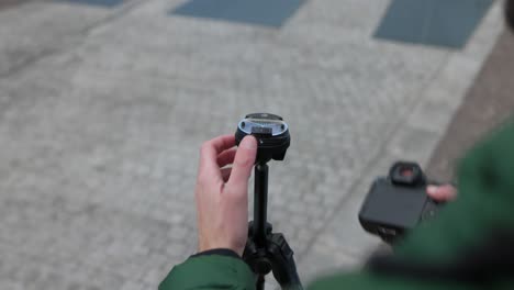 Person-adjusting-a-mirrorless-camera-on-a-tripod,-camera-video,-photo-equipment