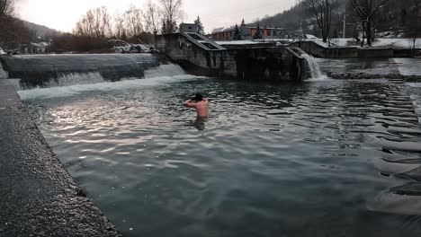 Niño-Bañándose-En-El-Hielo-Del-Río-Frío-Invierno