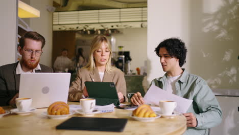 three colleagues having a business meeting in a coffee shop