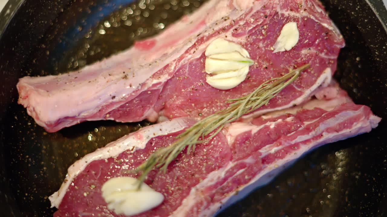 Juicy ribeye steak meat beef being prepared with rosemary and garlic