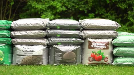 a comprehensive display of gardening supplies, featuring a variety of soil and fertilizer bags arranged neatly in a lush green setting