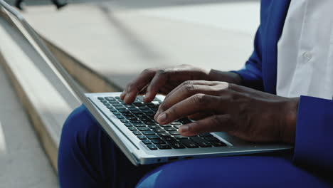 close-up of hands typing on a laptop