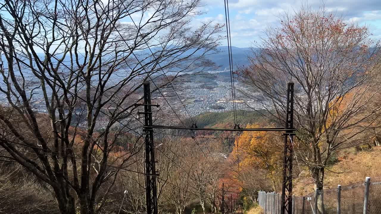 Looking back out of cable car going up mountain with panorama cityscape in distance