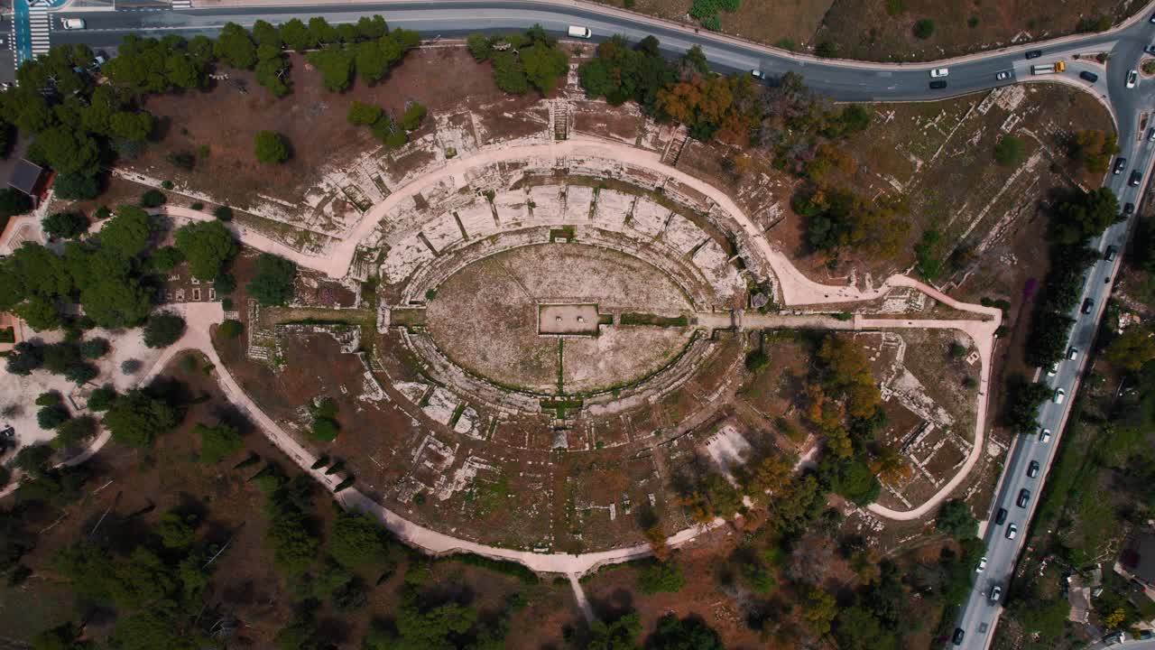 Roman amphitheater and ancient archaeological park in historic Siracusa, southern Italy. Aerial drone