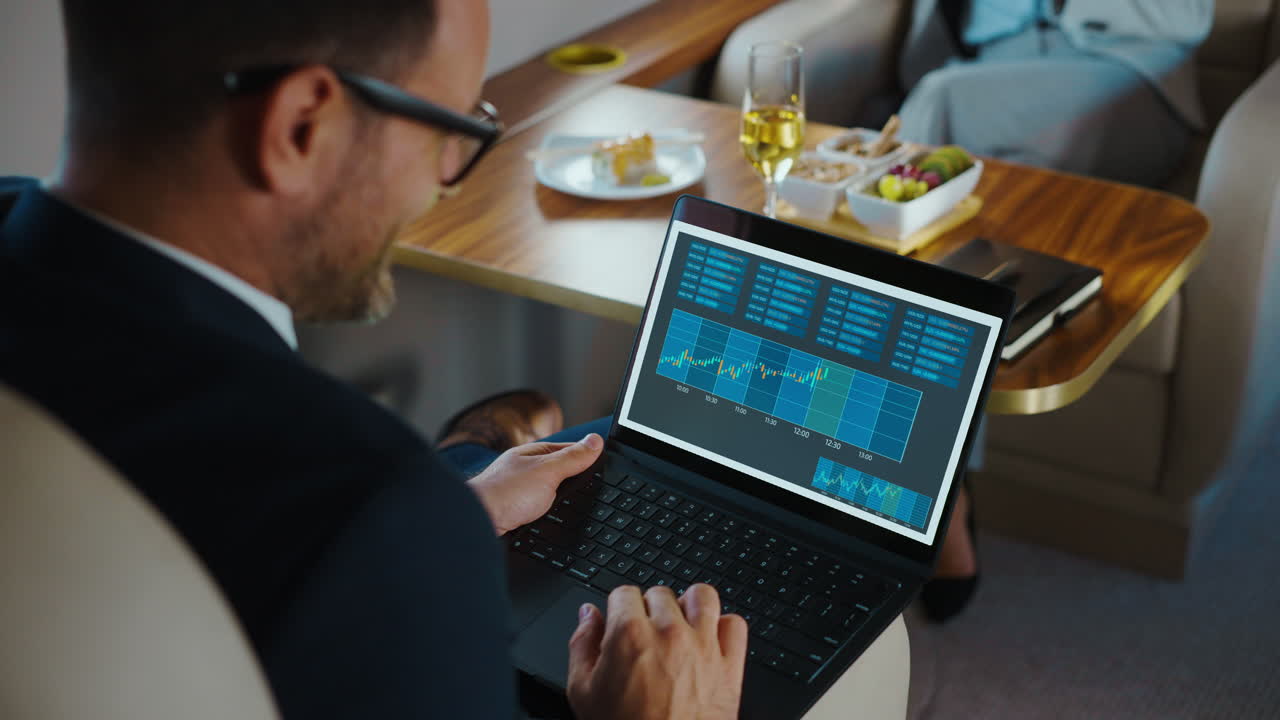 Man Analyzing Financial Charts on Laptop