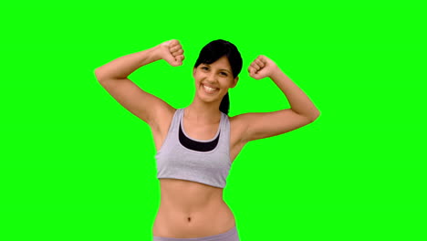 mujer atlética tensando sus brazos en la pantalla verde