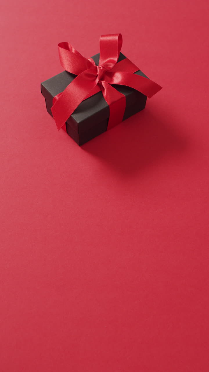video vertical del presente con cinta roja sobre fondo rojo