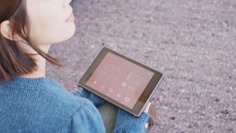 video of asian woman sitting and checking weather on tablet at home