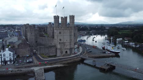 ancient caernarfon castle welsh harbour town aerial view medieval waterfront landmark close left dolly