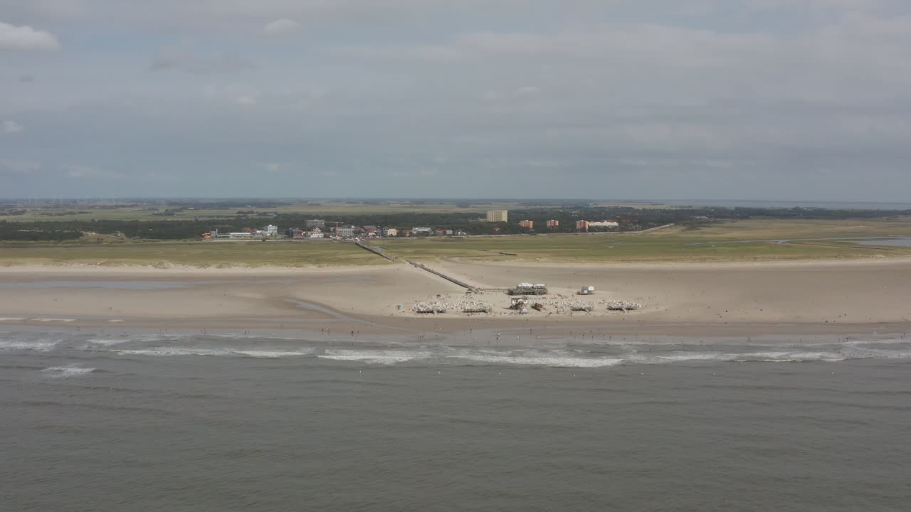 Drone - Aerial panorama circling shot of the sandy beach with tourists and people in St. Peter Ording at the north sea, schleswig holstein, germany, 25p