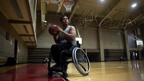 a man in a wheelchair plays basketball on an indoor court