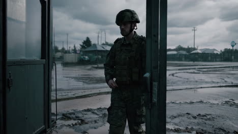 military personnel at a checkpoint in a muddy area