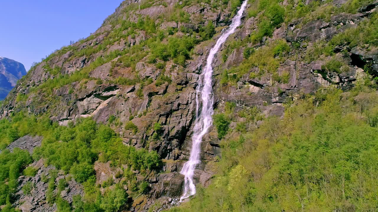 una cascada que fluye por un acantilado cerca de flam, noruega - retire la revelación aérea