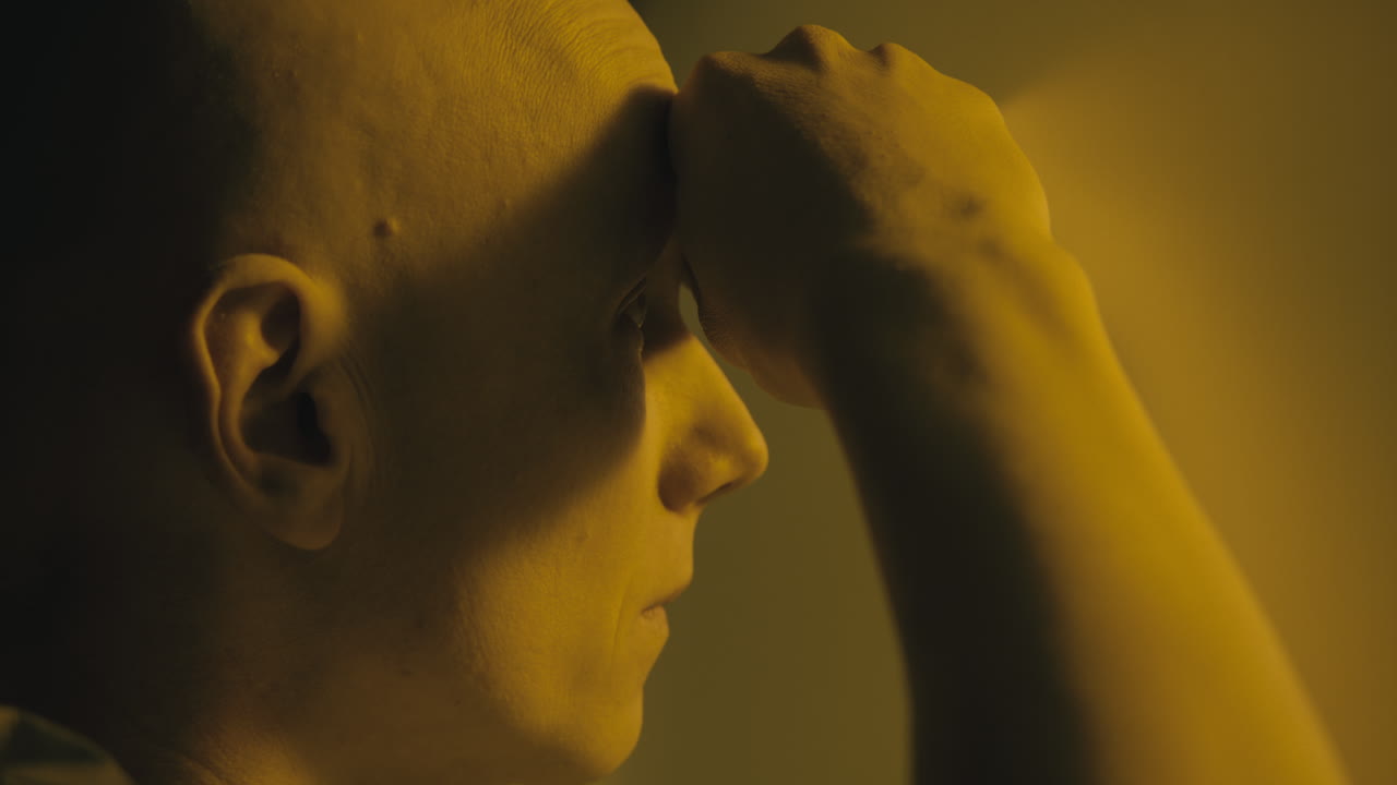 A bald man looks through the yellow glass in the operation room