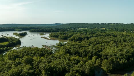 backward dolly reveals fishermen at wetlands waterways at lake sequoyah, middle fork white river, in northwest ar - hyperlapse aerial