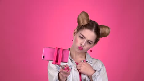 teenage girl taking a selfie with a pink selfie stick