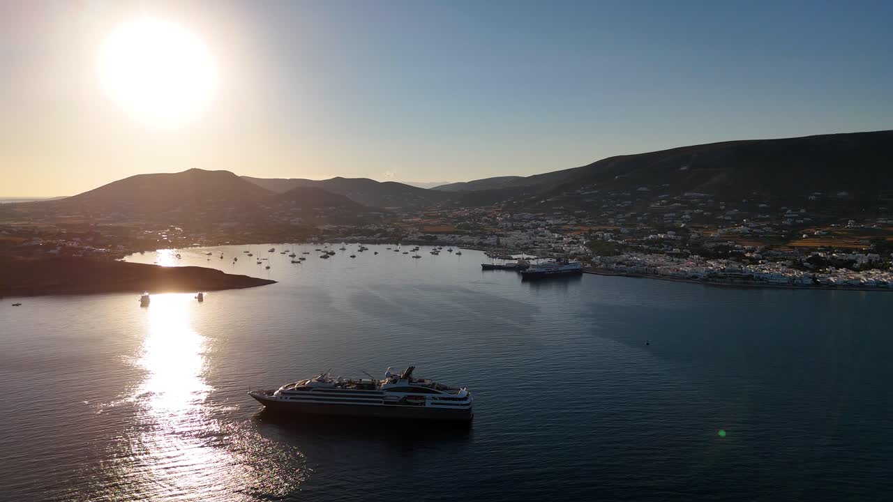 A cruise ship catches the low sun in the bay on the Mediterranean island of Paros, Greece