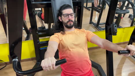 hombre latino con barba y cabello largo haciendo ejercicio en el equipo rechazó