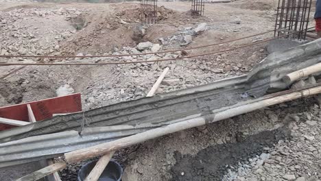 trabajador de la construcción vertiendo hormigón desde una lámina metálica del techo hasta la base