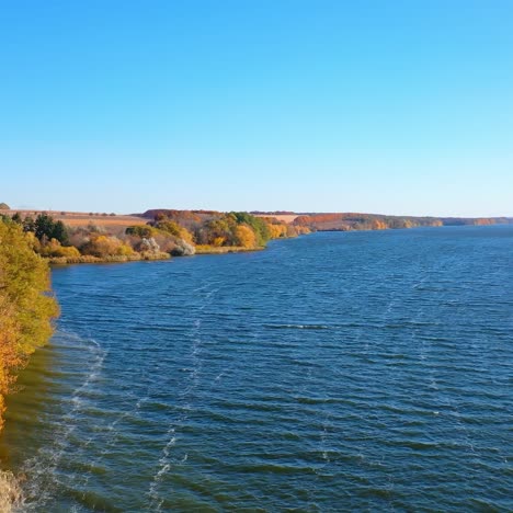 stunning scenery of the dark blue river and colorful bank. ripple surface of dark waters. a top view wide river and autumn forest