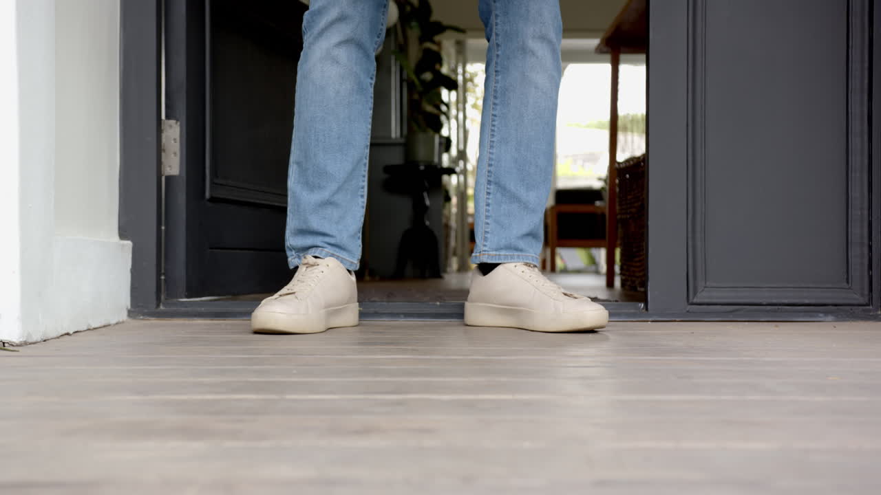 Receiving package delivery, man picking up box at home entrance, copy space