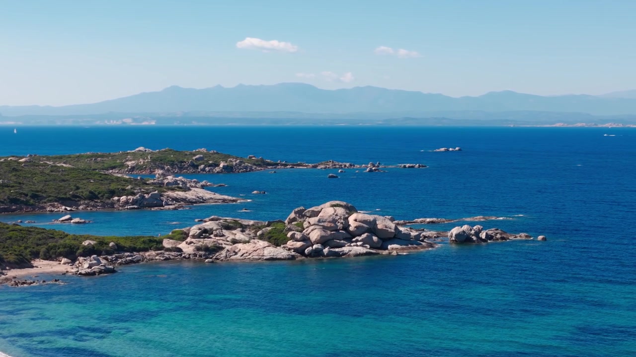 Vista aerea di una costa rocciosa e un mare blu cristallino in una giornata di sole in Sardegna