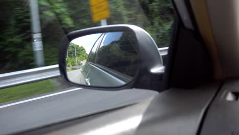 view of the side mirror of car. left-hand traffic