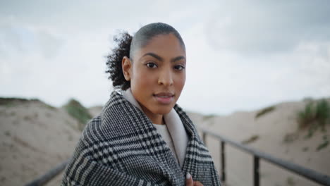 African-american-walking-sand-dunes-closeup.-Serene-woman-turning-looking-camera