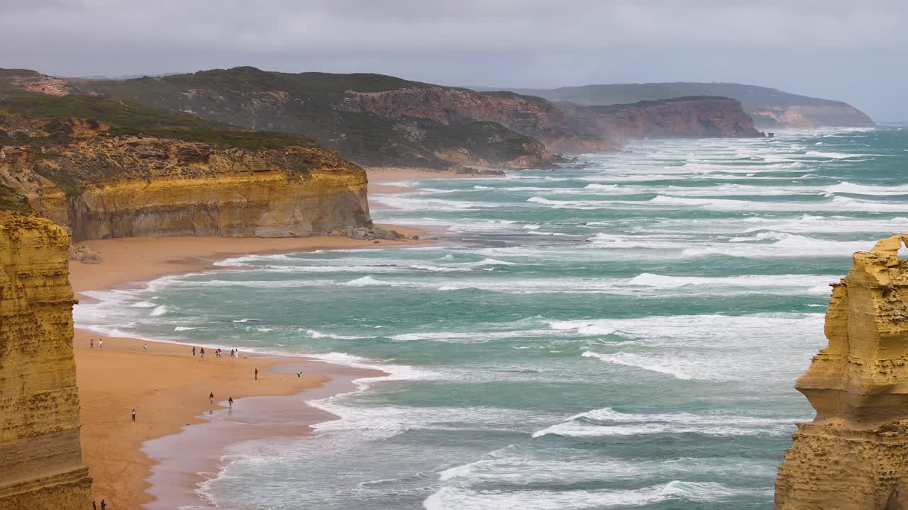 Dynamic coastal waves and cliffs at Twelve Apostles, Port Campbell, captured under overcast skies with steady camera movement