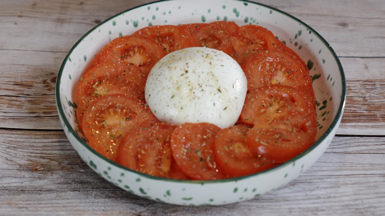oil being sprayed onto an uncooked burrata ready to be cooked in the oven