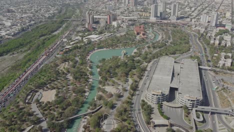 High-aerial-shot-of-traffic-queuing-alongside-the-Paseo-Santa-Lucia,-Monterrey,-Nuevo-Leon