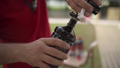 caucasian male hands fuel tiki torch garden backyard day