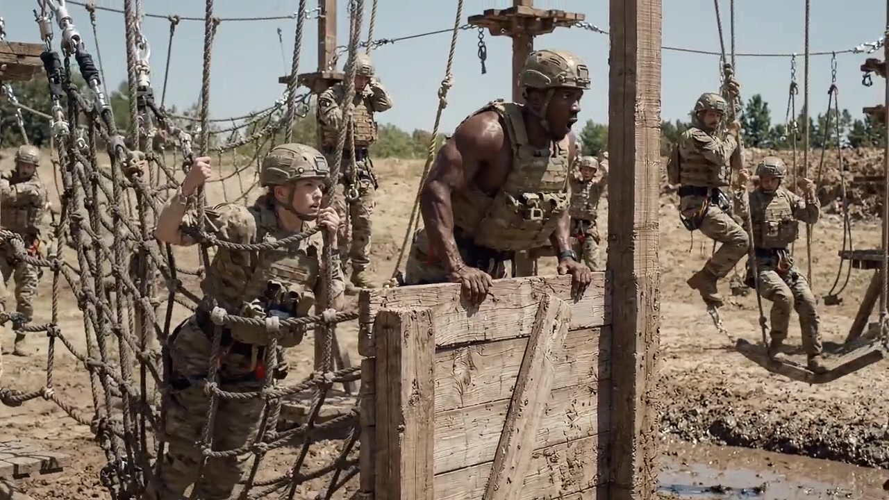 Personale militare affronta un percorso a ostacoli durante un'esercitazione di addestramento, superando sfide e migliorando le capacità di lavoro di squadra in un ambiente esterno rigoroso.
