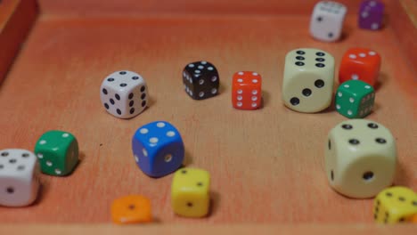 colorful dices rolling into a wooden box, slow motion, close up view