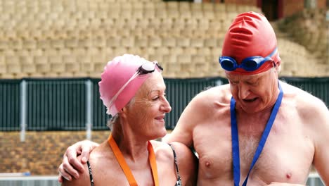 excited senior couple showing medal