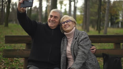 elderly couple taking a selfie in the park