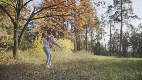 mother and daughter playing in autumn park