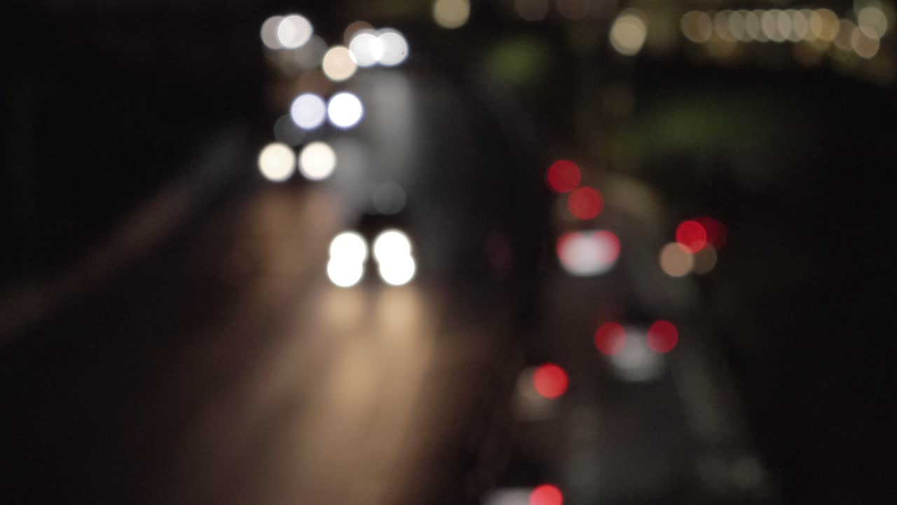hermoso bokeh de los faros de los coches en una autopista de dos pisos en una gran ciudad por la noche